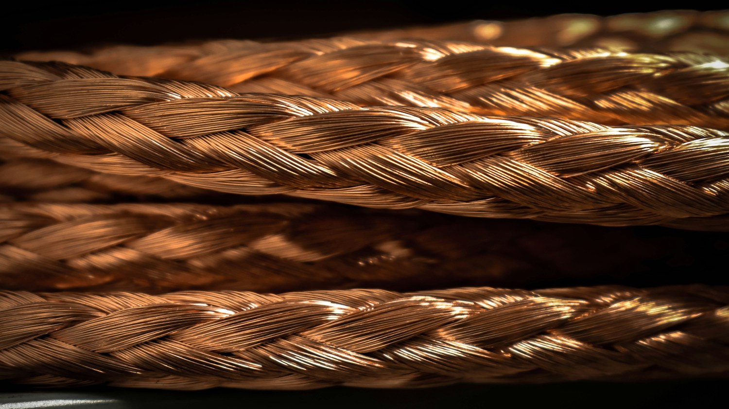Primer plano de cables trenzados de cobre sobre fondo oscuro
